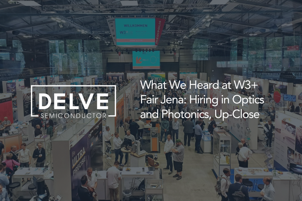 Delve Semiconductor blog cover featuring a busy exhibition hall at W3+ Fair Jena, with attendees networking among optics and photonics company stands. Overlaid text reads: “What We Heard at W3+ Fair Jena: Hiring in Optics and Photonics, Up-Close.” The Delve Semiconductor logo appears on the left.